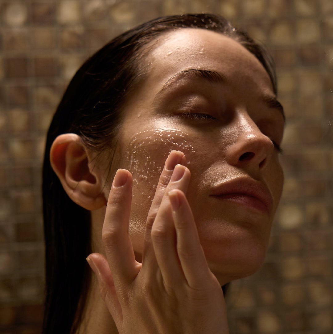 Model exfoliating face in the shower