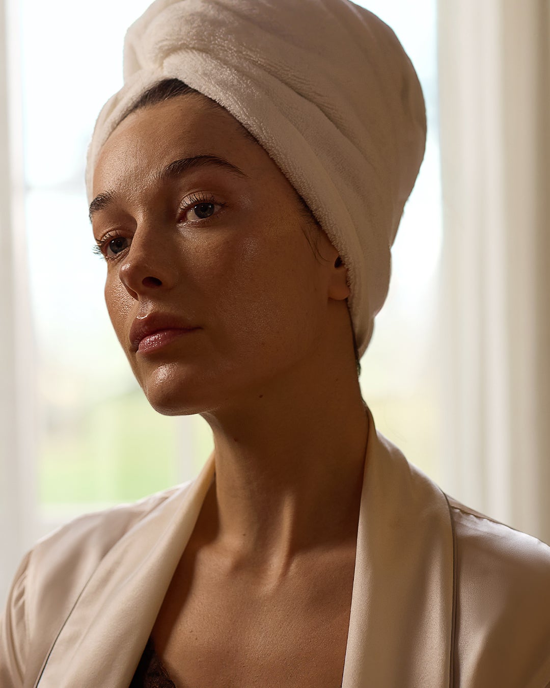 Model in head turbine and a silk robe, post shower gazing into a mirror.