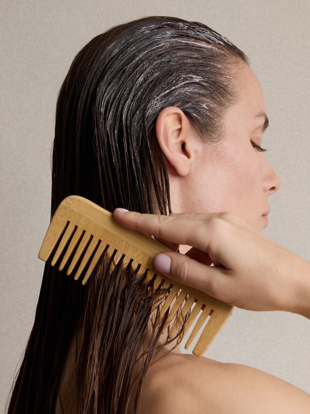 Model combing Pink Hair & scalp mud through wet hair