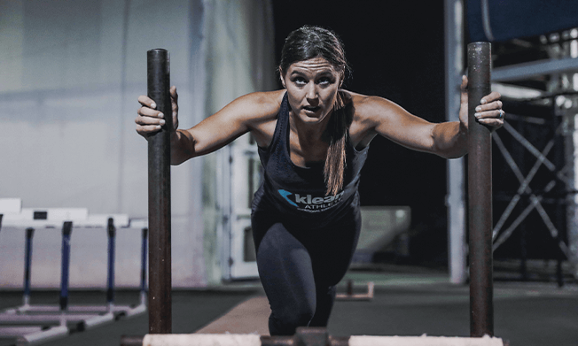 Klean Athlete woman pushing weights in the gym